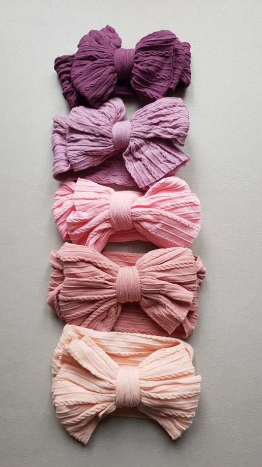 Five textured bows are arranged vertically on a background.