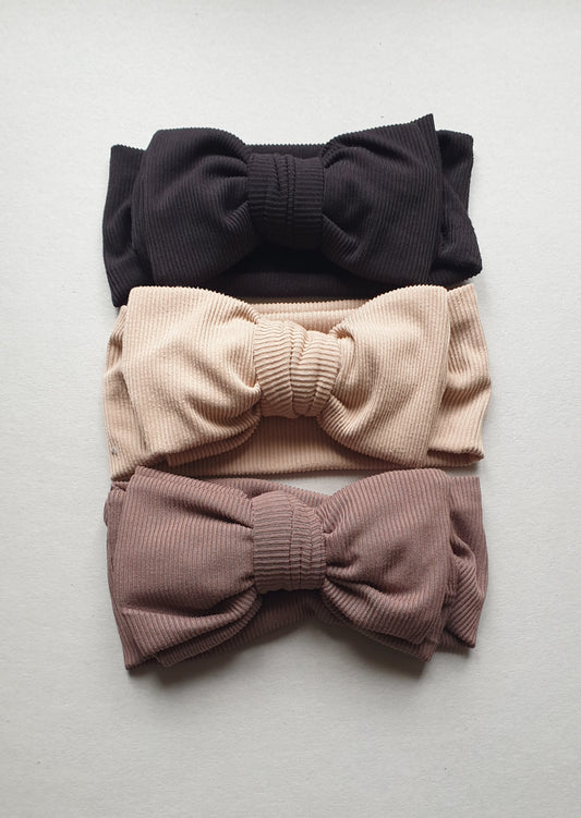 Three ribbed headbands are stacked on a light background.