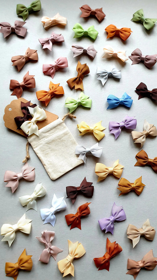 An array of colorful, fabric bows in pastel and earthy tones.