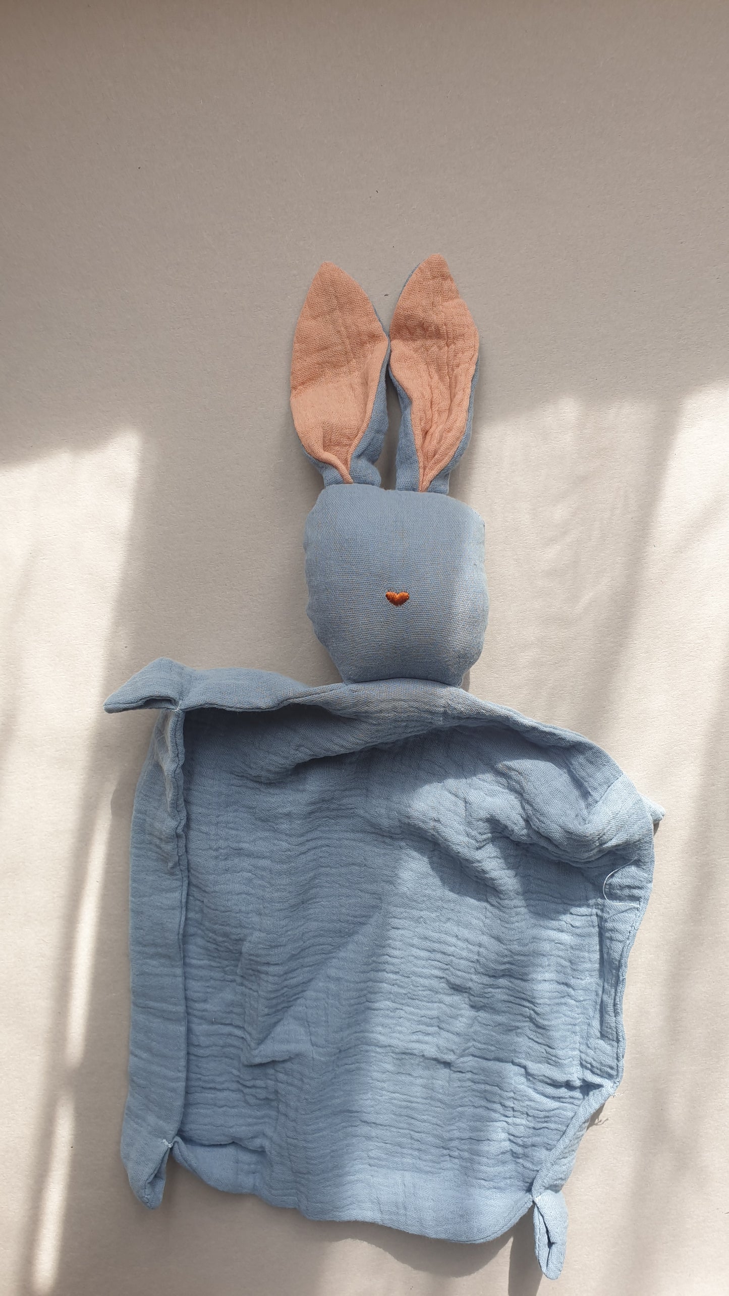 Blue rabbit toy with floppy ears and a gentle expression.