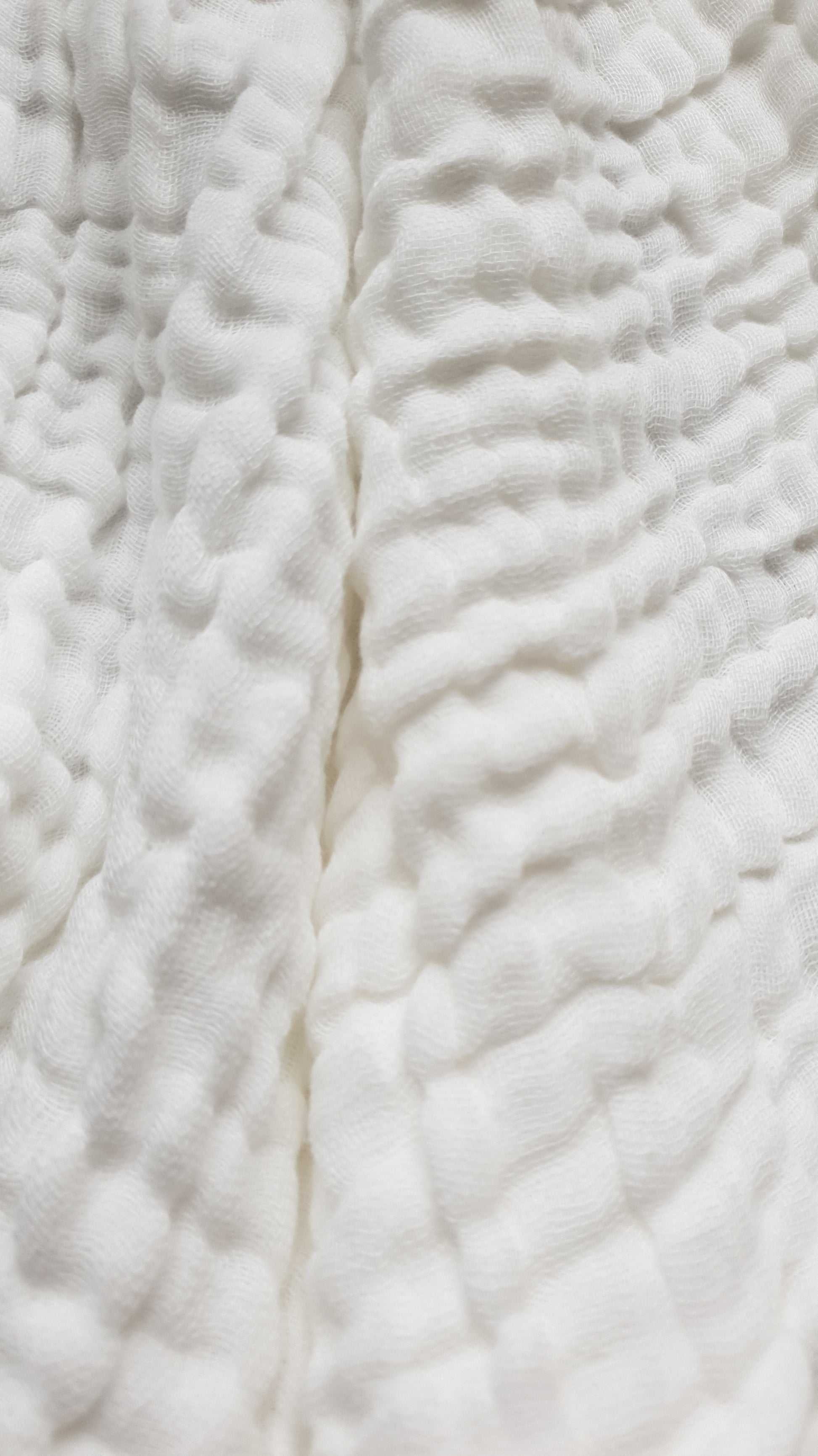Close-up of white, textured fabric with a wavy pattern.