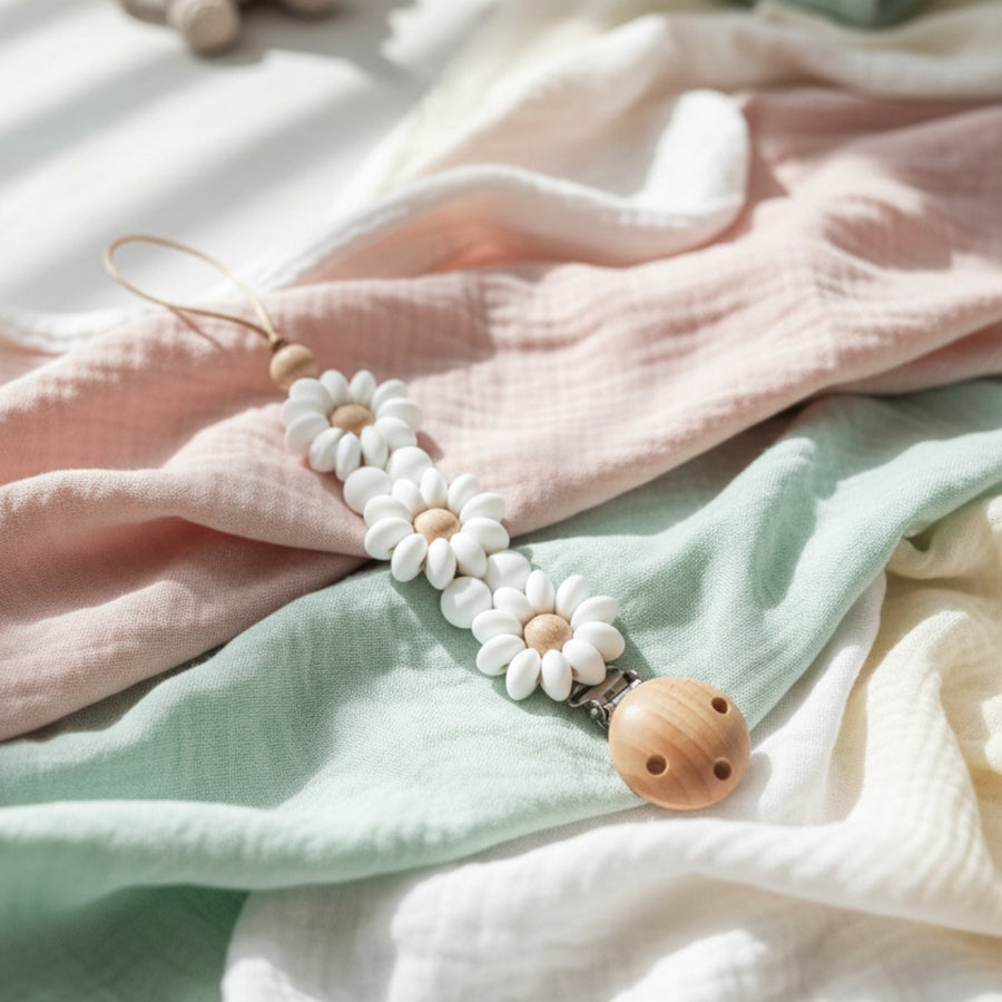 A daisy-themed pacifier clip with white flower beads.
