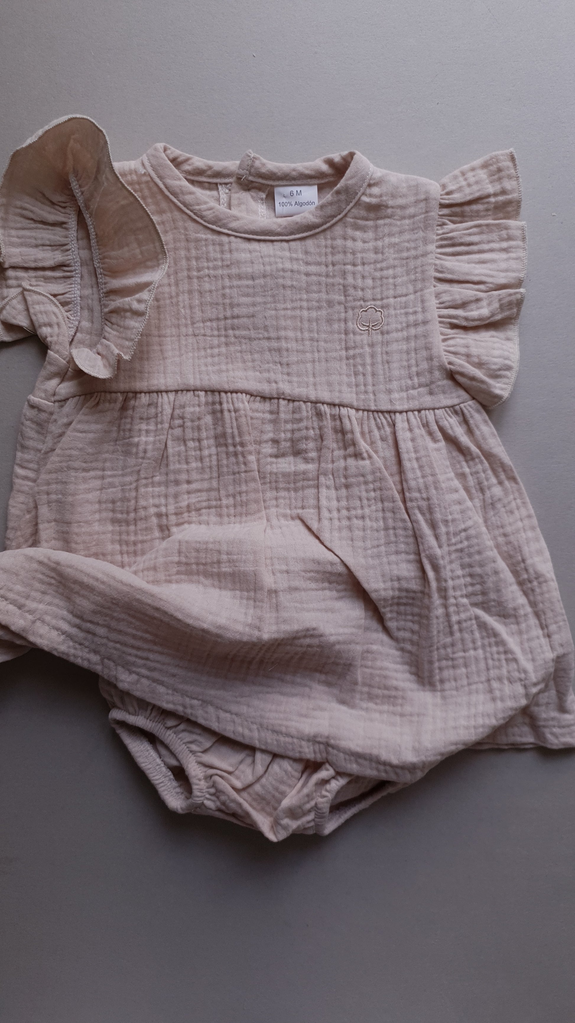 Soft pink infant dress with sleeves and matching bloomers.