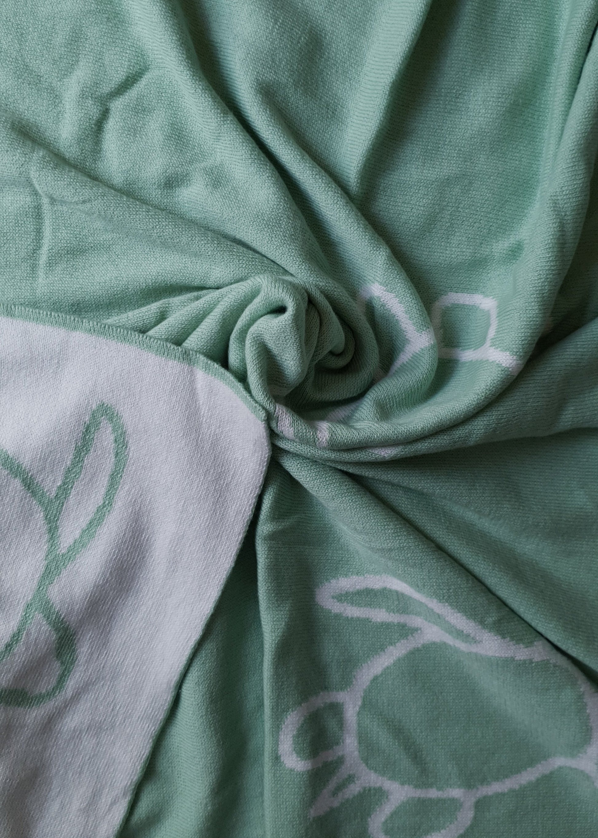 A soft green towel with white turtle outlines.