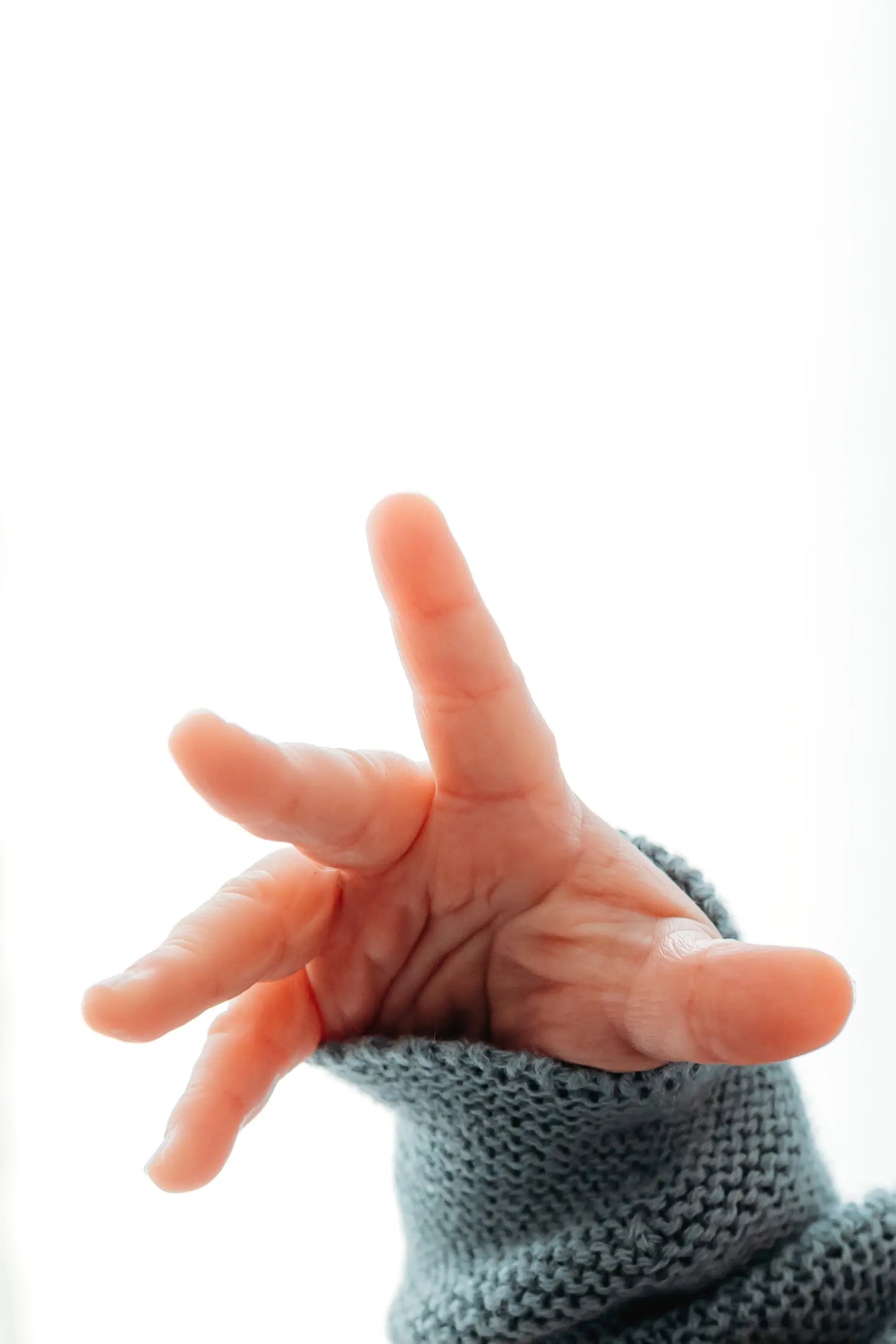 A child's hand reaching outward with fingers spread.