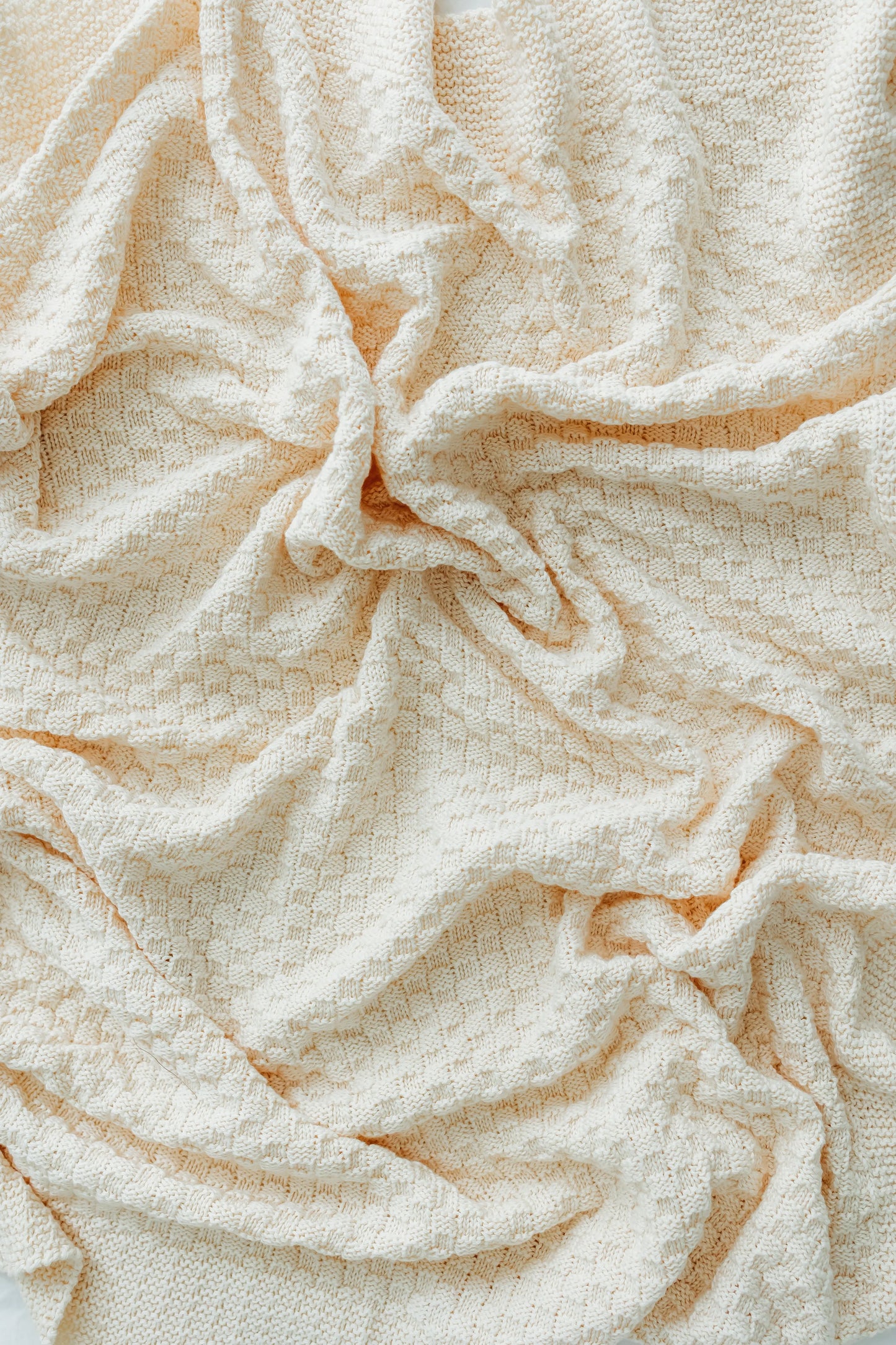 Crinkled ivory fabric with a subtle diamond pattern.