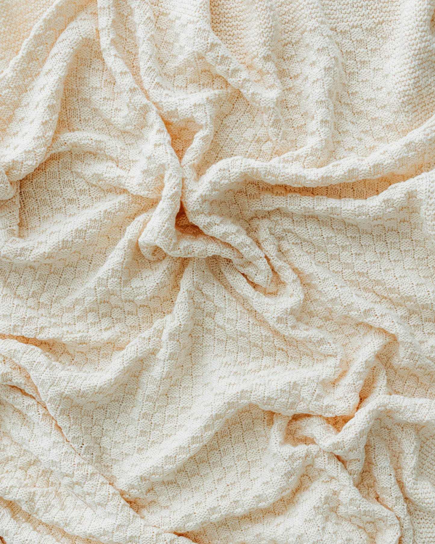 Crinkled ivory fabric with a subtle diamond pattern.