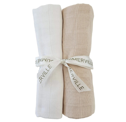 Two rolled blankets, one white and one beige, tied together.