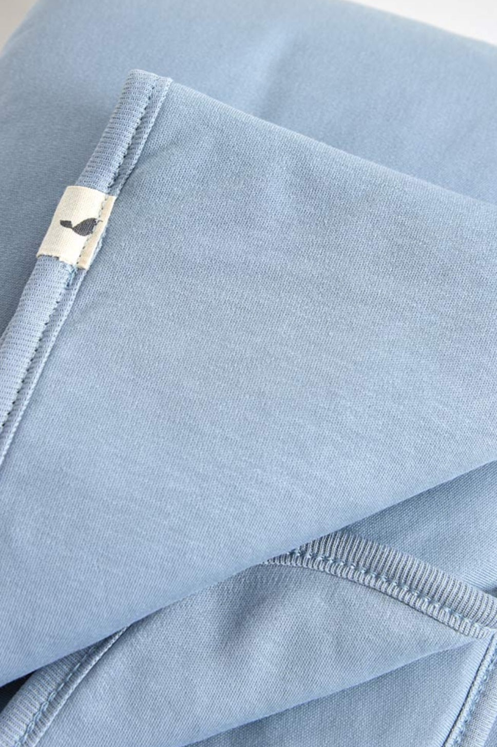 A close-up image of neatly folded light blue fabric.