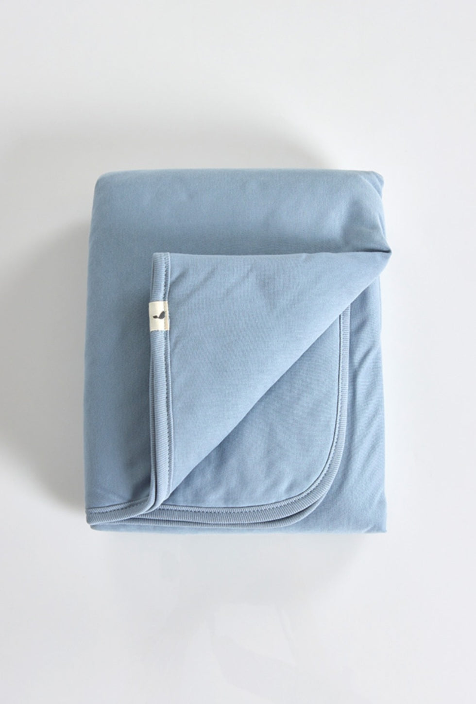 Folded light blue fabric with a subtle stitching detail.