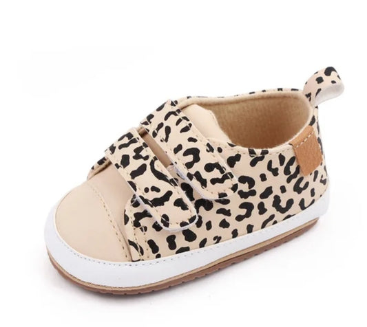 Beige baby shoe with black leopard print and Velcro straps.