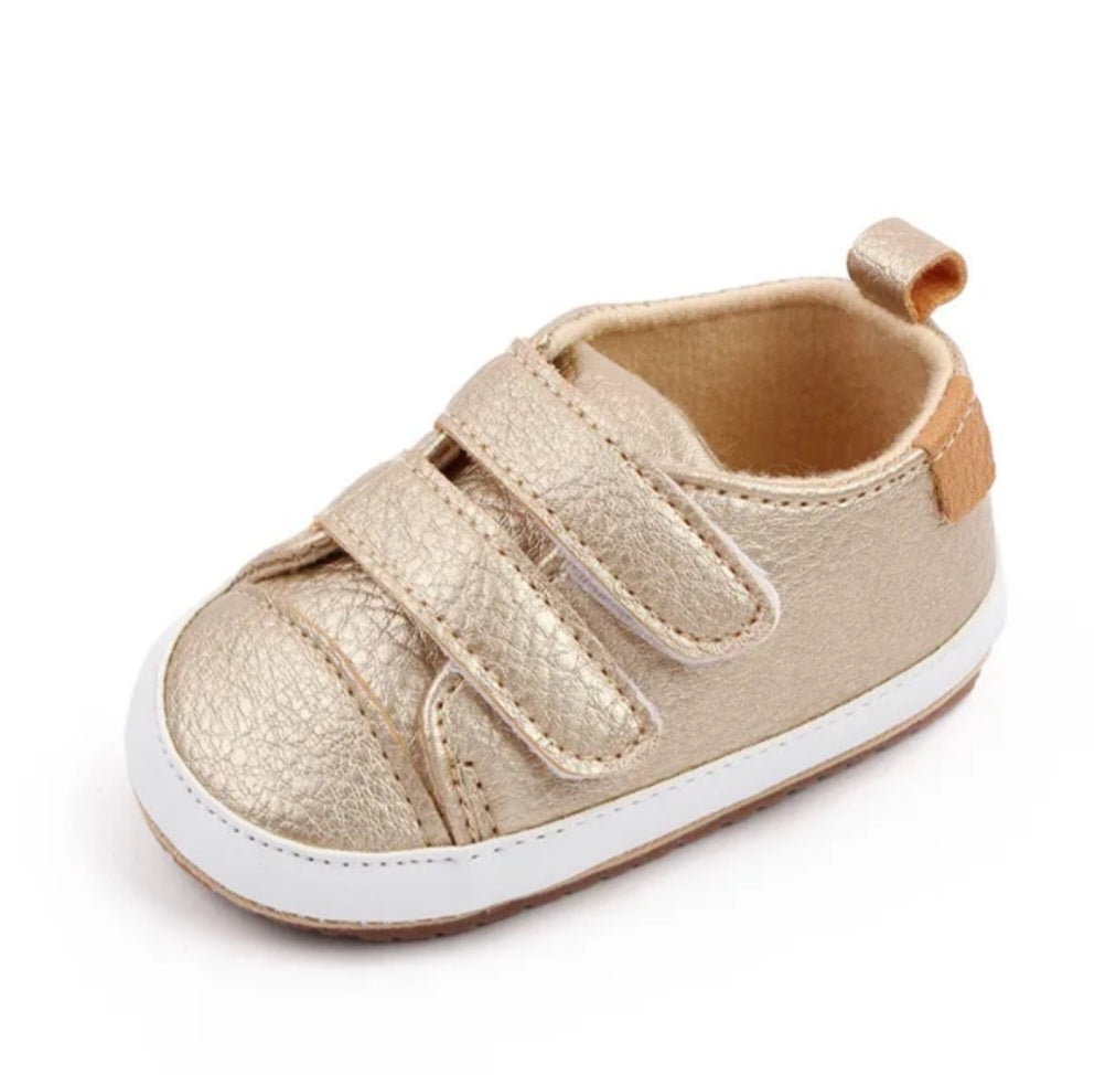 Golden toddler shoe with Velcro straps and a white sole.
