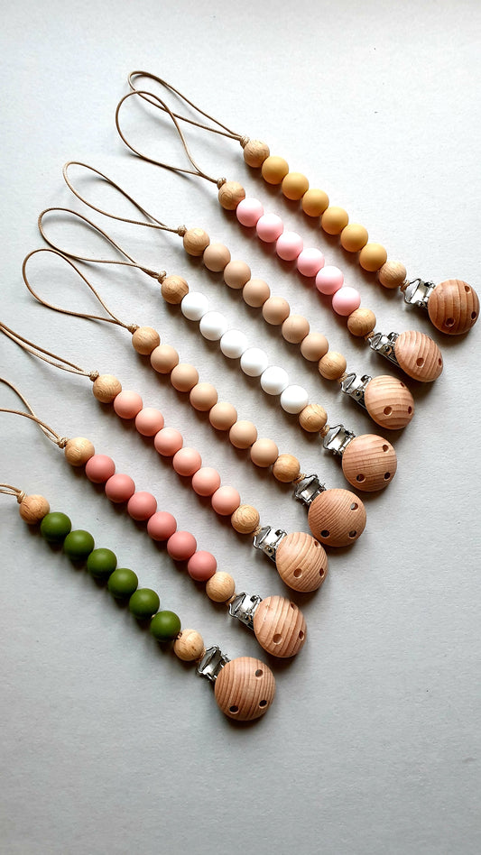 A set of seven beaded pacifier clips with colored beads.