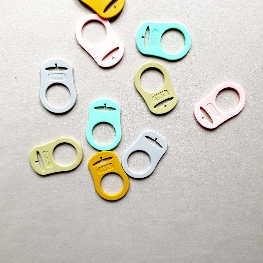 A scattered arrangement of colorful plastic bag clips.