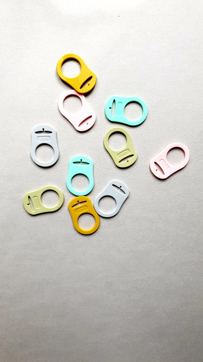 A scattered arrangement of colorful plastic bag clips.